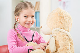 child using a stethoscope on bear
